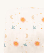 A close up of the sun and moon Little Green Radicals hooded blanket. Showing the cute sun and moon print detail on white organic cotton fabric.