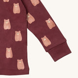A close up of the Little Green Radicals brown bear pyjama set showing the elasticated cuff detail and a close up of the cute brown bear on organic cotton fabric.