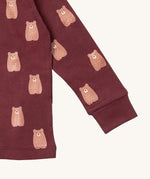 A close up of the Little Green Radicals brown bear pyjama set showing the elasticated cuff detail and a close up of the cute brown bear on organic cotton fabric.