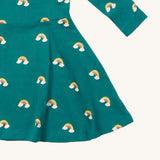 A close up of the Little Green Radicals rainbow turquoise twirly dress showing the gentle gather detail on organic cotton fabric.