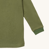 A close up of the Little Green Radicals green chive waffle long sleeve cosy top cuff and hem detail on green organic fabric