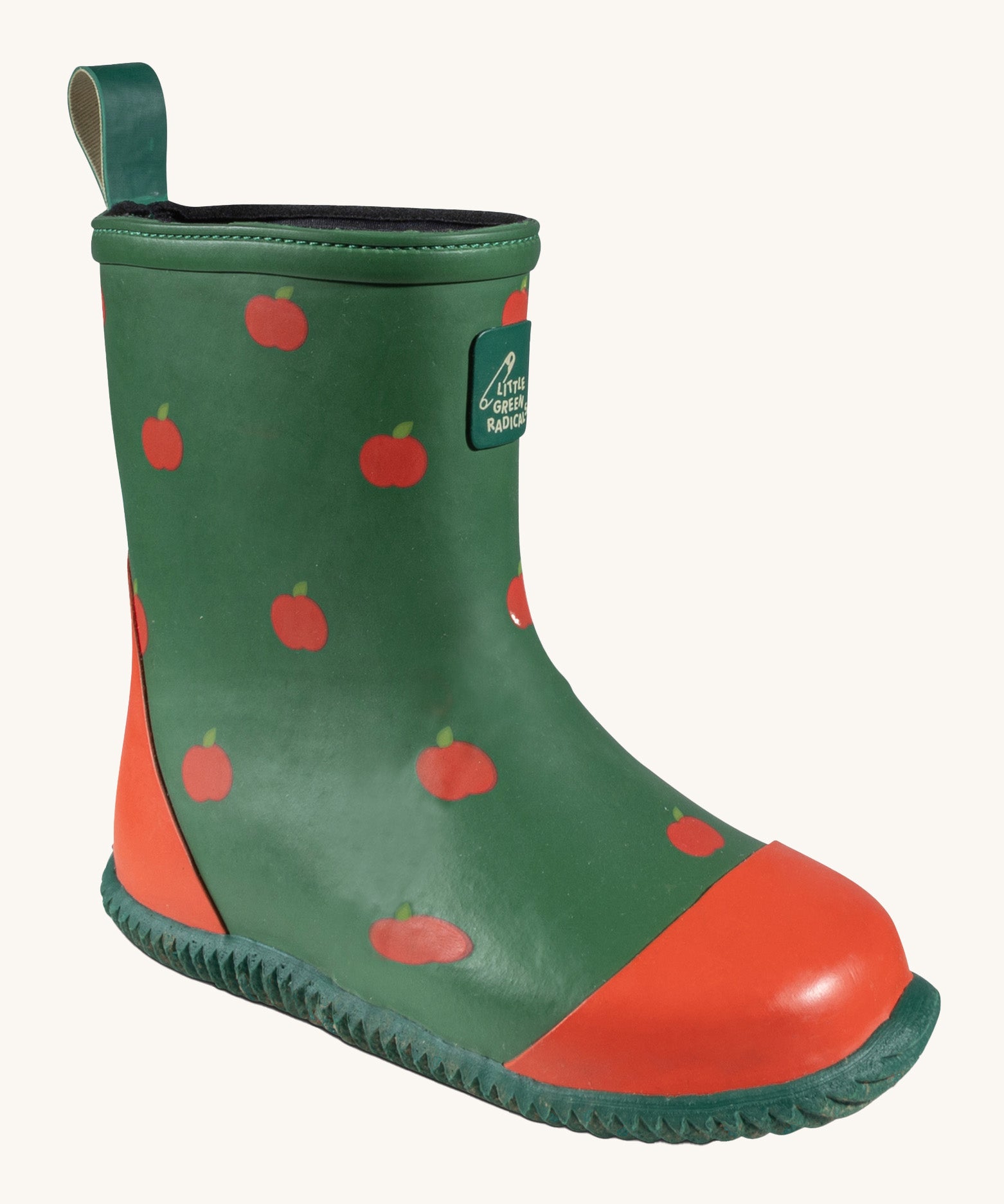 A single Little Green Radicals kid wellington boot. Showing the red apples printed all over the natural rubber. Features a red toe cap, gripped sole and pull-on tab for easy fitting