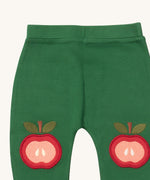 A close up of the Little Green Radicals kneepatch joggers in red apple showing the apple applique detail on green organic cotton fabric