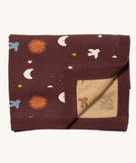 Little Green Radicals baby blanket in flying birds. A GOTS organic cotton blanket in brown with cute birds flying around the stars, the moon and the sun. Features a matching textured brown border and a yellow striped textured inner.