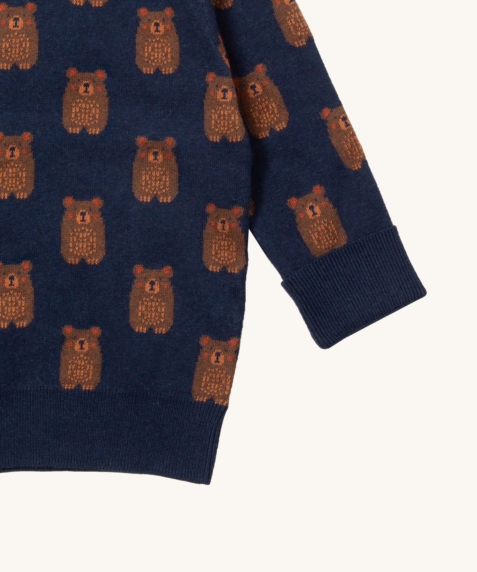 A close up of the Little Green Radicals navy teddy bears knitted jumper showing the cute brown bear detail and thick cuff detail on navy organic cotton fabric. 