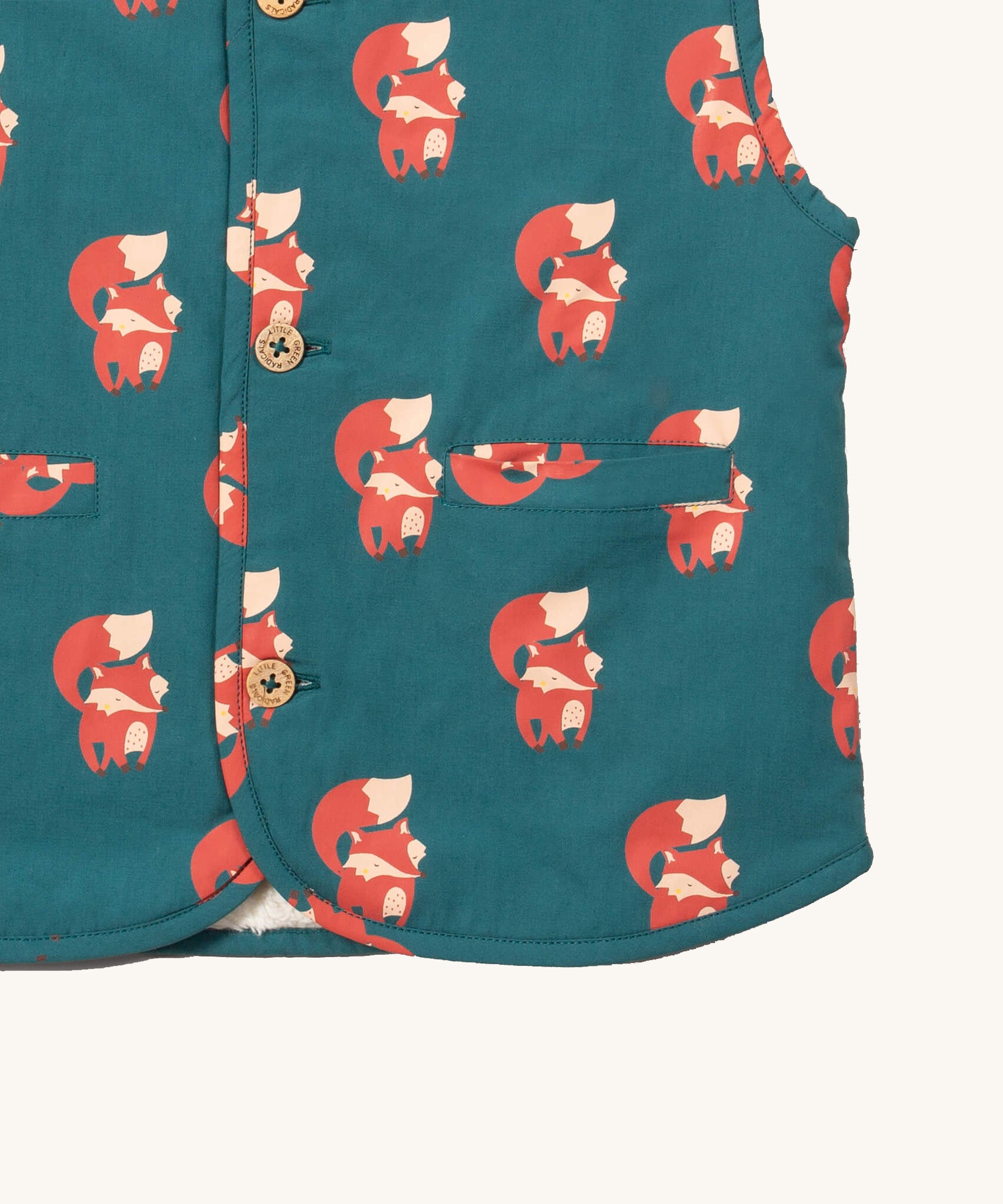 A close up of the Little Green Radicals reversible gilet in red foxes and sherpa lined. Showing the pouch pocket detail and a close up of the cute fox print on GOTS organic cotton fabric. 