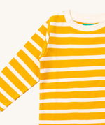 A close up of the Little Green Radicals gold striped long sleeve top that's available at Babipur. Showing the yellow and white stripe detail on organic cotton fabric.