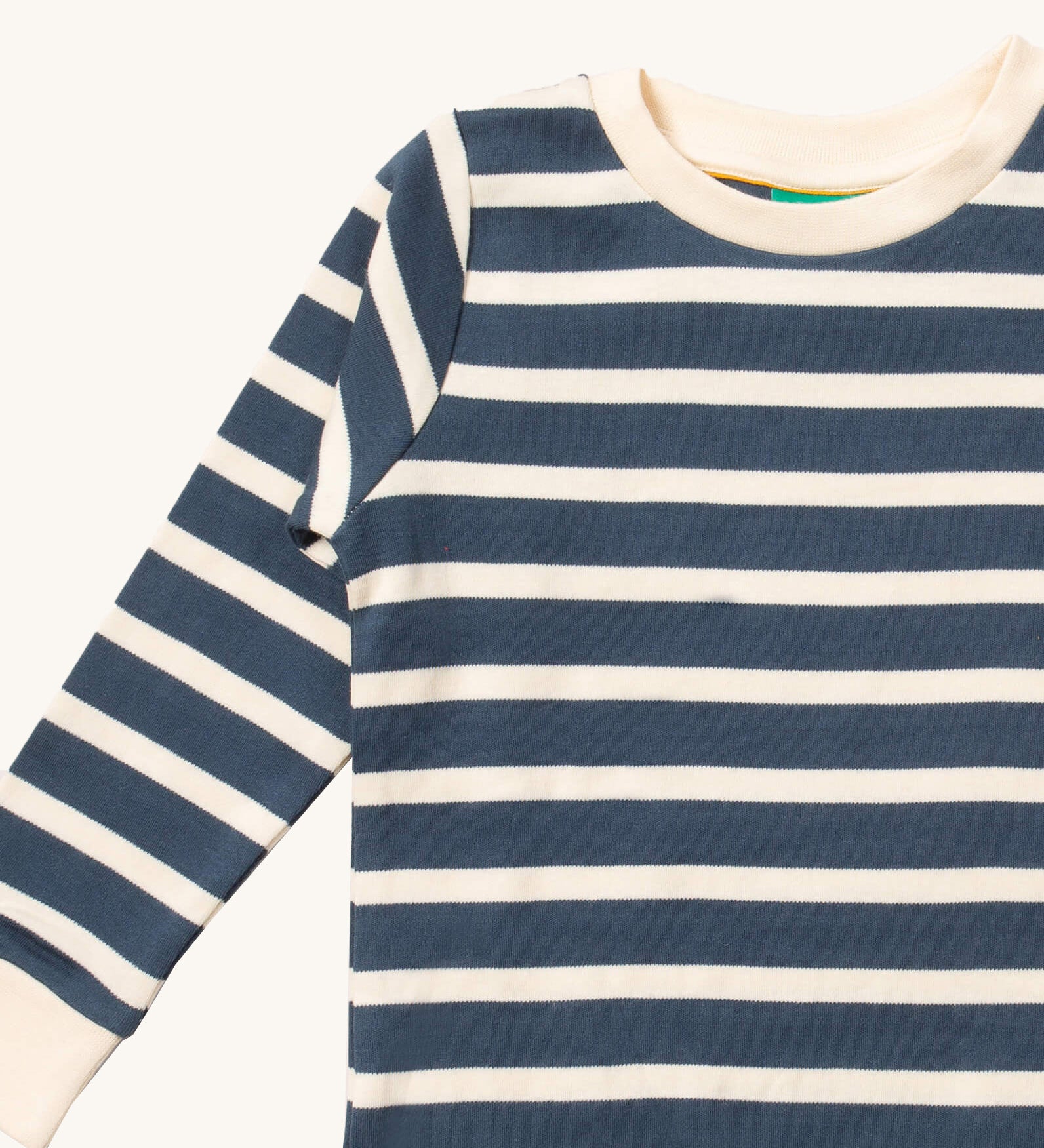 A close up of the Little Green Radicals midnight blue striped long sleeve top that's available at Babipur. Showing the navy and white stripe detail on organic cotton fabric.