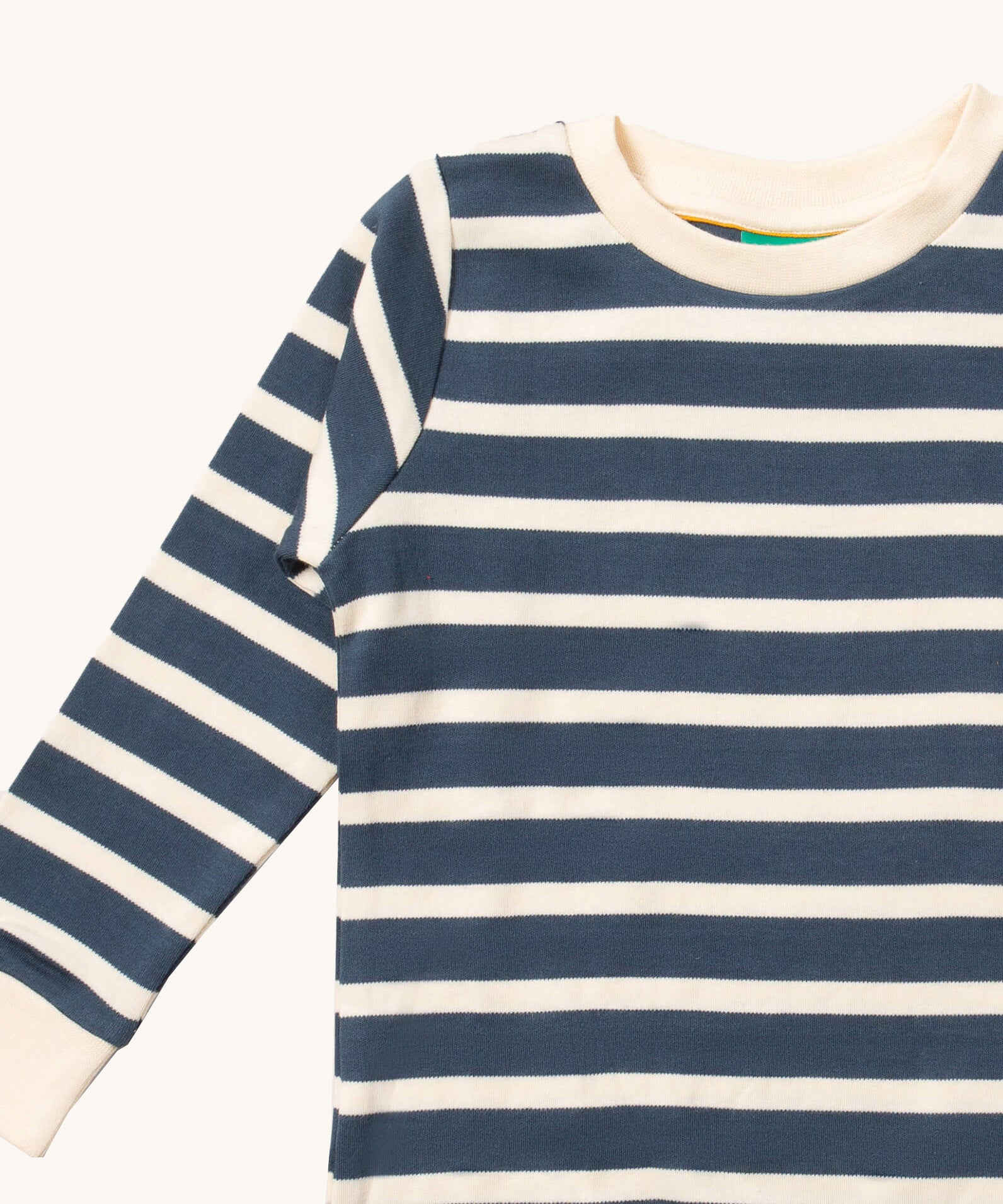 A close up of the Little Green Radicals midnight blue striped long sleeve top that's available at Babipur. Showing the navy and white stripe detail on organic cotton fabric.