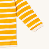 A close up of the Little Green Radicals gold striped long sleeve top that's available at Babipur. Showing the white cuff detail on striped organic cotton fabric.