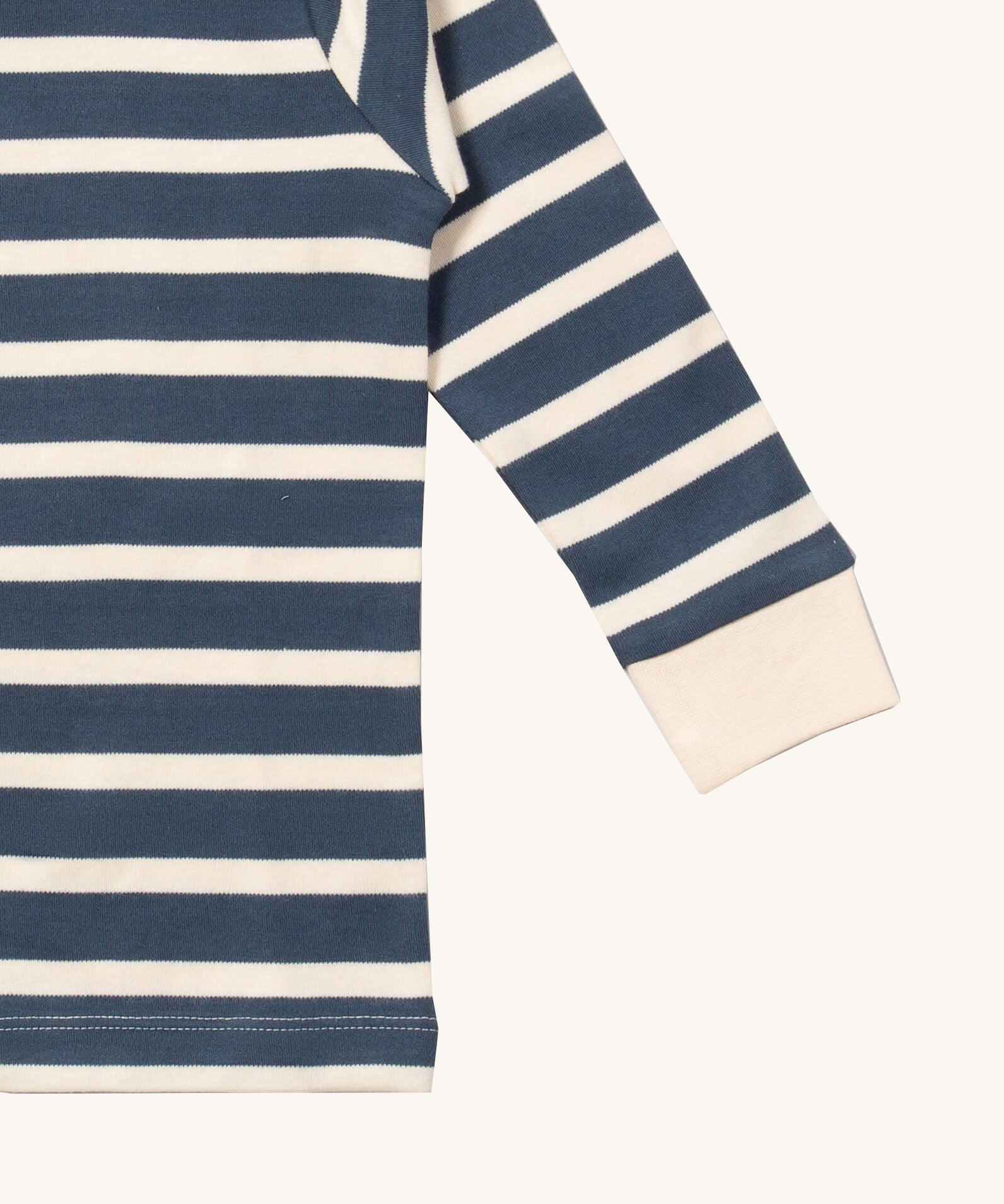 A close up of the Little Green Radicals midnight blue striped long sleeve top that's available at Babipur. Showing the white cuff detail on striped organic cotton fabric.