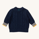 Little Green Radicals navy aran knitted jumper available at Babipur. A GOTS organic cotton jumper in dark navy with a thick cable knit on the body and a striped design on the cuffs.