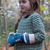 A child wearing the Little Green Radicals snuggly knitted jumper in olive stripe. Showing the knitted detail and cream cuff on green and cream striped GOTS organic cotton fabric available a at Babipur.