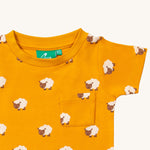  this t-shirt has a fun sheep print on orange fabric