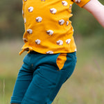 A child happily playing outside wearing the Little Green Radicals Counting Sheep Short Sleeve T-Shirt. Made from GOTS organic cotton