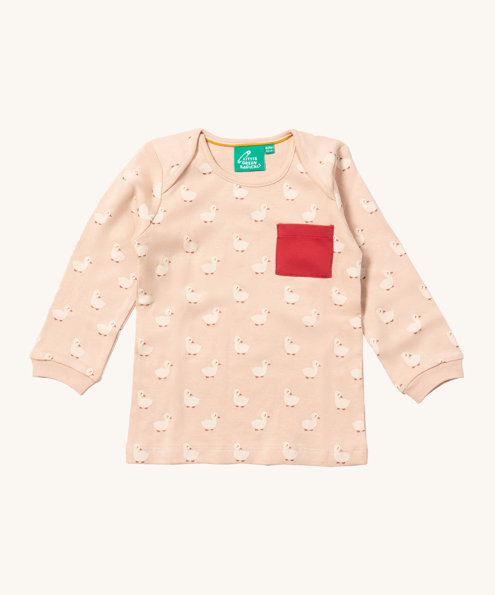 A close up of the Little Green Radicals puddle ducks sleeve t-shirt. Showing the elasticated cuff detail and red pouch pocket detail on peach organic cotton fabric