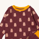 A close up of the Little Green Radicals brown bear pyjama set showing the yellow trim and brown bear detail on organic cotton fabric.