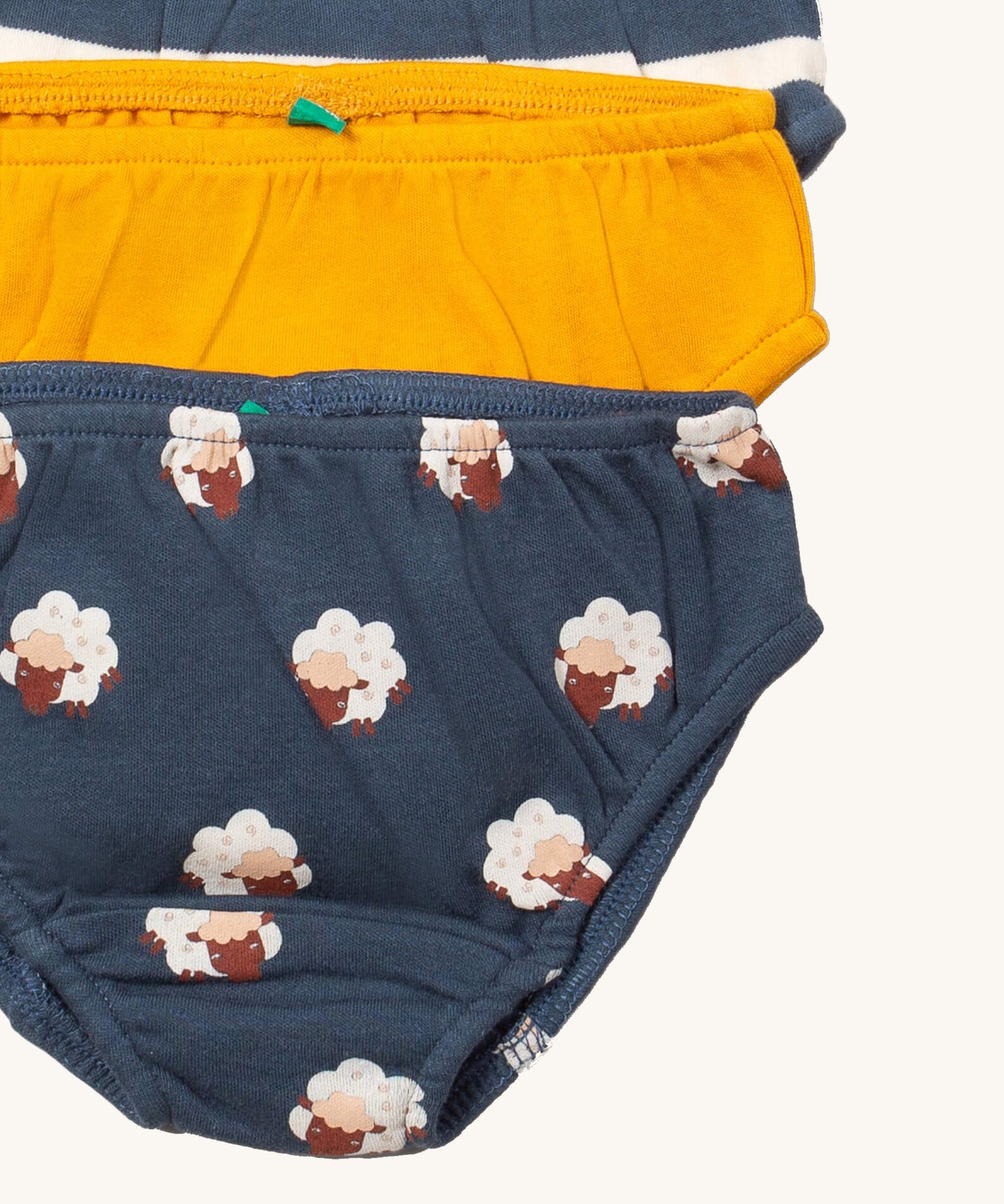 A close up of the Little Green Radicals sleeping sheep underwear 3 pack. Showing the trim detail and and a close up of the prints of sheep on organic cotton fabric