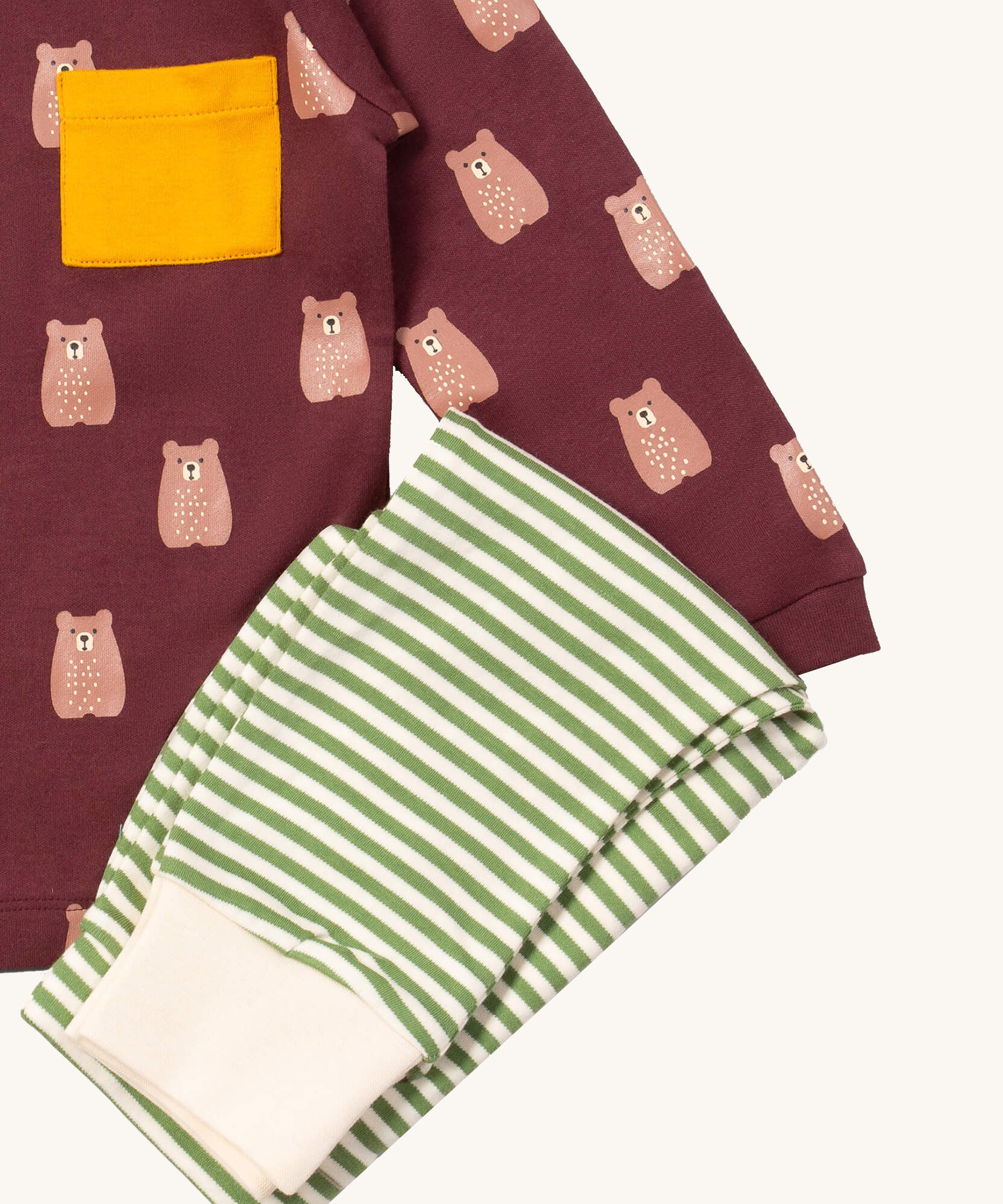A close up of the Little Green Radicals green and cream striped jogger on top of the maroon brown bear t-shirt on organic cotton fabric
