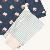 A close up of the Little Green Radicals light blue striped jogger on top of the navy sleeping sheep long sleeve t-shirt on organic cotton fabric