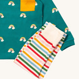 A close up of the Little Green Radicals rainbow inspired striped  jogger on top of the turquoise rainbow long sleeve t-shirt on organic cotton fabric