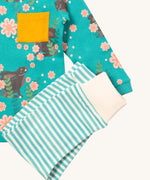 A close up of the Little Green Radicals light blue striped  jogger on top of the winter rabbit long sleeve t-shirt. Showing the soft elasticated leg cuff detail on organic cotton fabric
