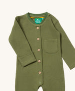 A close up of the Little Green Radicals green chive waffle playsuit showing the button fasteners and pocket detail on green organic cotton fabric