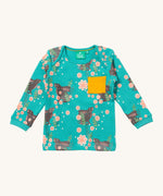 Little Green Radicals winter rabbits t-shirt available at Babipur. A GOTS organic cotton top with long sleeves in turquoise with prints of rabbits in pink flowers and a yellow chest pocket.