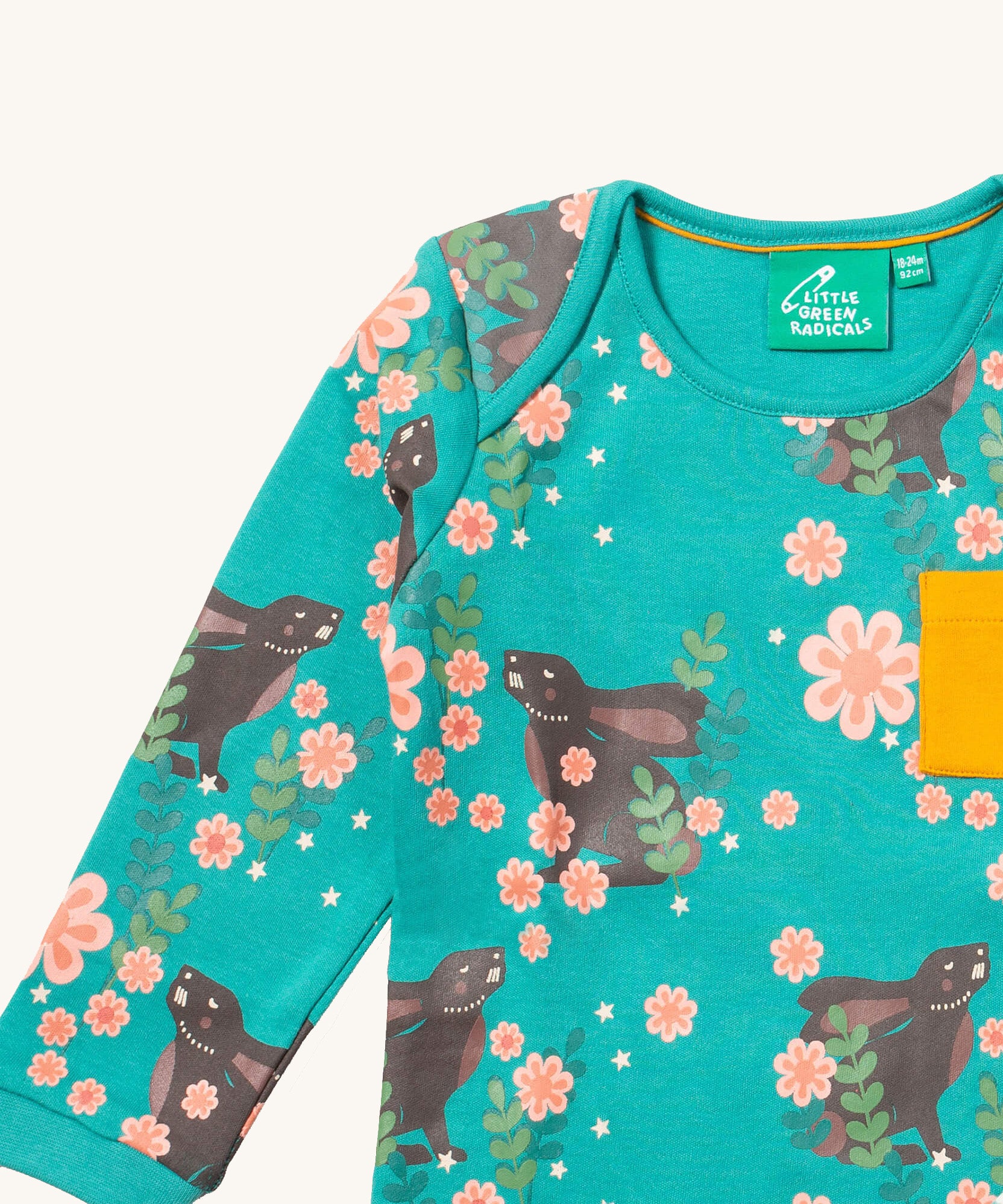 A close up of the Little Green Radicals winter rabbits t-shirt. Showing the rabbits in pink flowers print and collar trim detail.