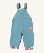 Little Green Radicals pale blue lined corduroy dungarees available at Babipur. A GOTS organic cotton dungaree in a corduroy style with a check inner. Features a small check pocket and 2 side pockets with a sun embroidery under the pocket 