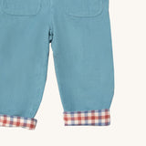 A close up of the Little Green Radicals pale blue lined corduroy dungarees  showing the back pockets and the turned up leg cuff showing the check design detail