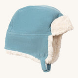 Little Green Radials sherpa fleece cosy hat in pale blue available at Babipur. A GOTS organic cotton blue hat in a corduroy style with turn up ear flaps and a white sherpa style fleece inner. Features a chin strap with popper fastener for a secure fit