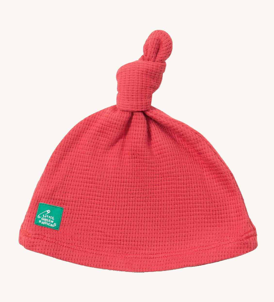 Little Green Radicals pink berry waffle tie hat available at Babipur. A GOTS organic cotton hat in pink with a knot on the top. Features a small brand patch on the brim
