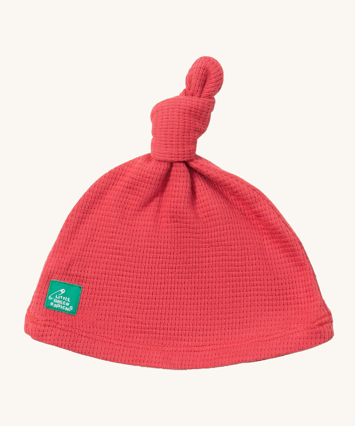 Little Green Radicals pink berry waffle tie hat available at Babipur. A GOTS organic cotton hat in pink with a knot on the top. Features a small brand patch on the brim