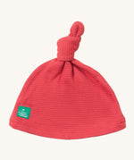 Little Green Radicals pink berry waffle tie hat available at Babipur. A GOTS organic cotton hat in pink with a knot on the top. Features a small brand patch on the brim