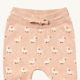 A close up of the Little Green Radicals puddle ducks knitted leggings showing the elasticated waist band and drawstring detail on light pink organic cotton fabric