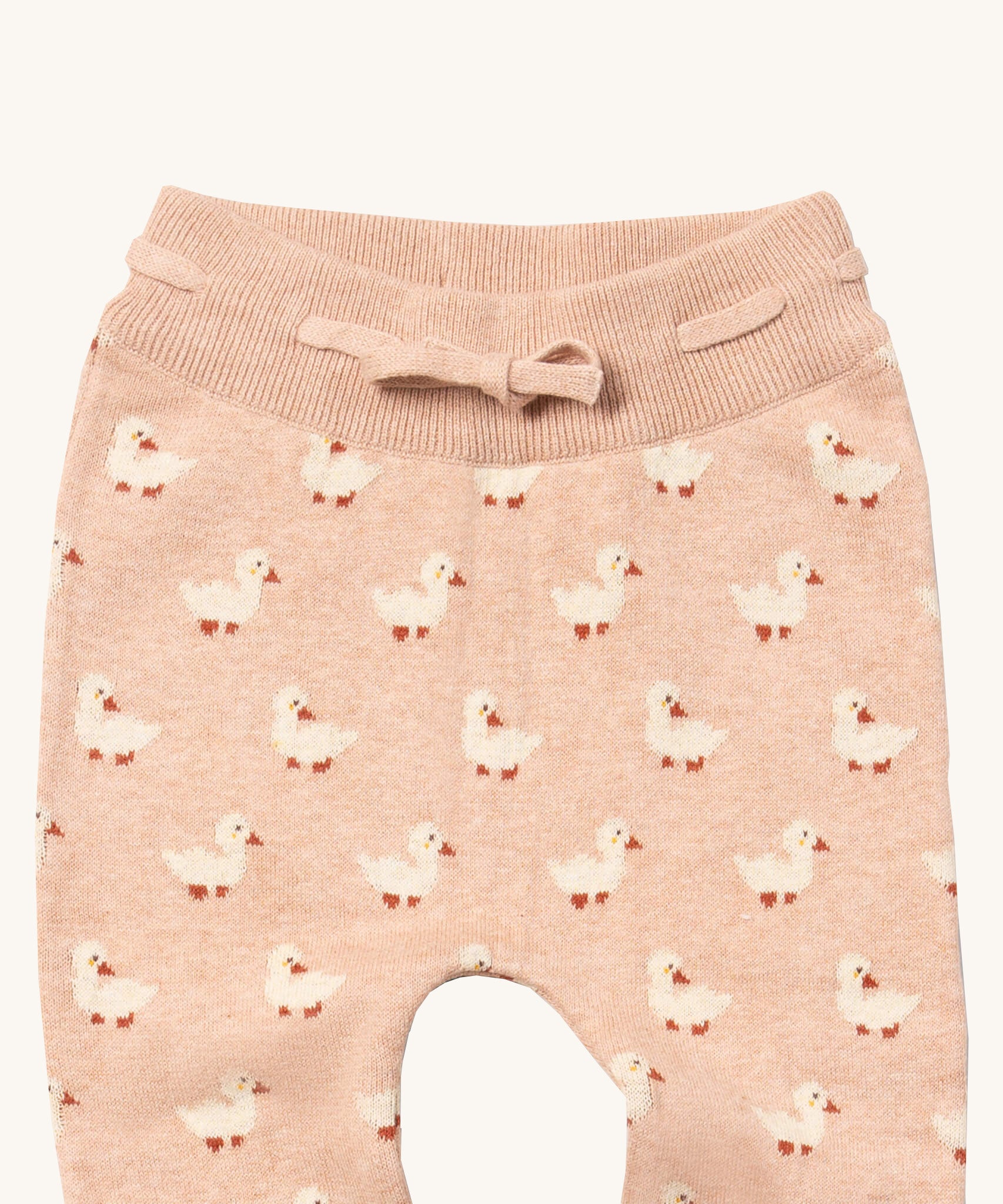 A close up of the Little Green Radicals puddle ducks knitted leggings showing the elasticated waist band and drawstring detail on light pink organic cotton fabric