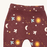 A close up of the Little Green Radicals flying birds quilted joggers. Showing the quilted stitch and flying prints detail on dark maroon organic cotton fabric.