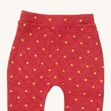 A close up of the Little Green Radicals red star quilted joggers. Showing the quilted stitch and yellow stars detail on red organic cotton fabric.