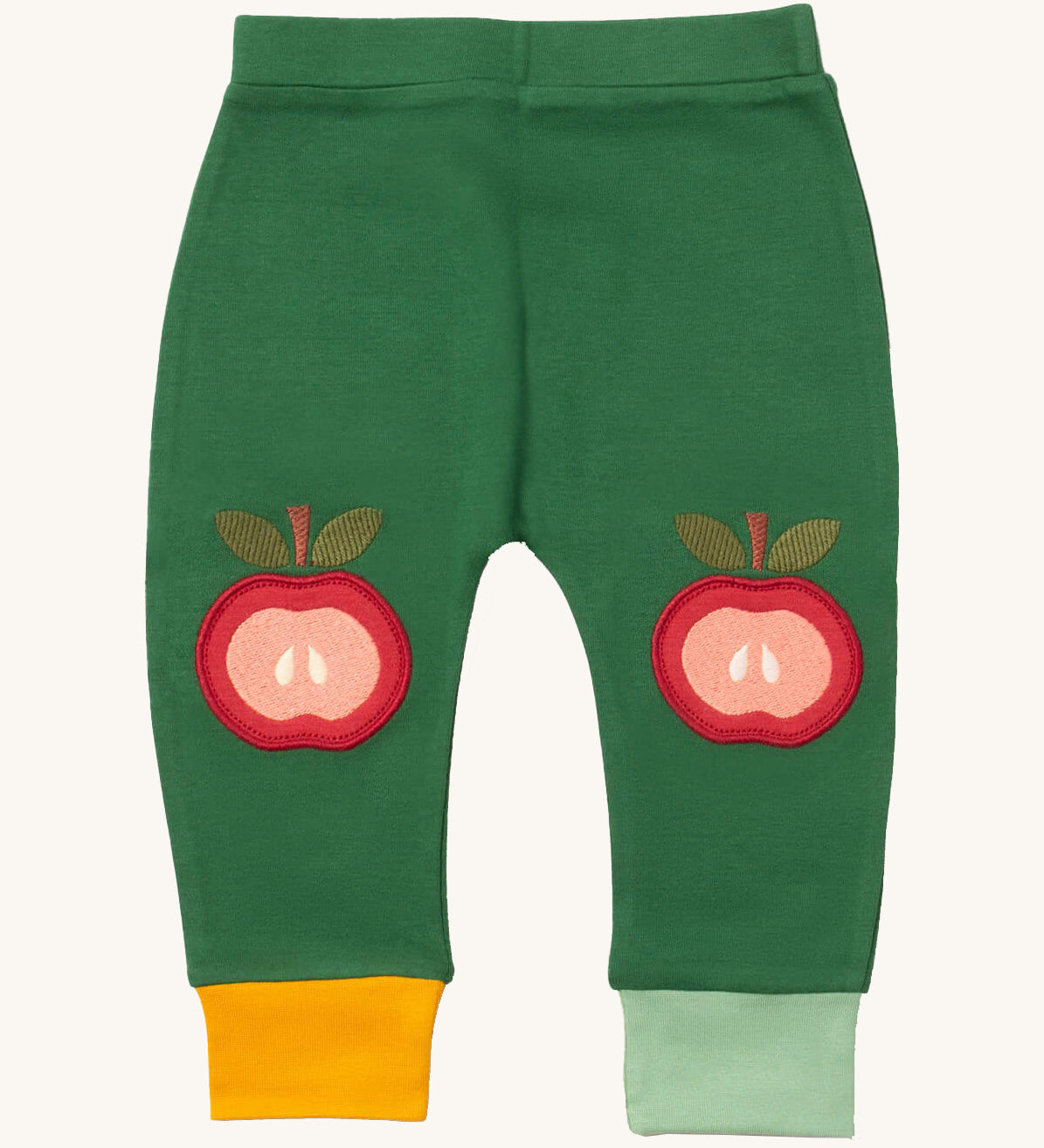 Little Green Radicals kneepatch joggers in red apple available at Babipur. A soft GOTS organic cotton green jogger pants with yellow and light green trim. Features a red apple applique as knee patches