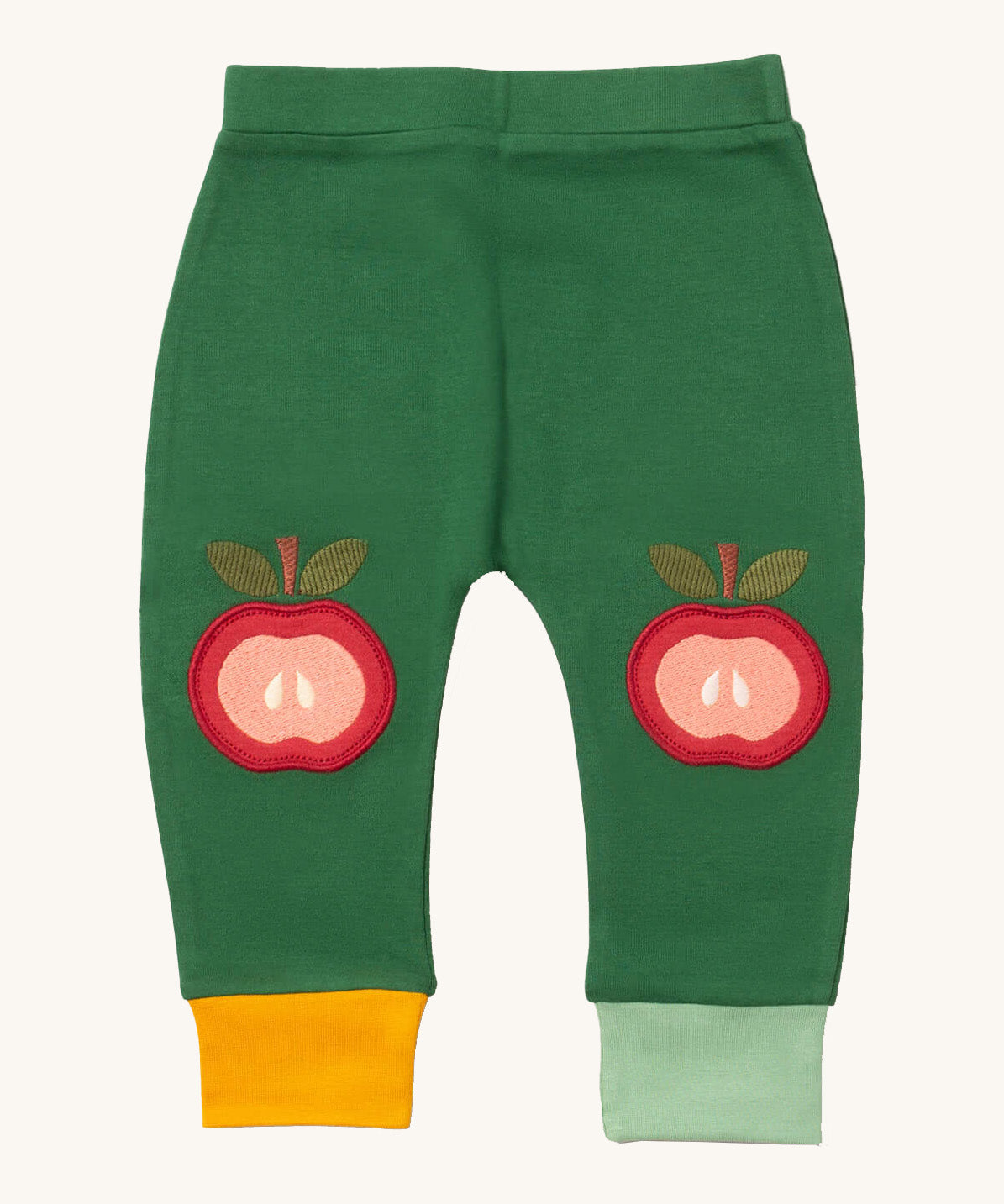 Little Green Radicals kneepatch joggers in red apple available at Babipur. A soft GOTS organic cotton green jogger pants with yellow and light green trim. Features a red apple applique as knee patches