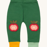 Little Green Radicals kneepatch joggers in red apple available at Babipur. A soft GOTS organic cotton green jogger pants with yellow and light green trim. Features a red apple applique as knee patches