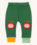 Little Green Radicals kneepatch joggers in red apple available at Babipur. A soft GOTS organic cotton green jogger pants with yellow and light green trim. Features a red apple applique as knee patches