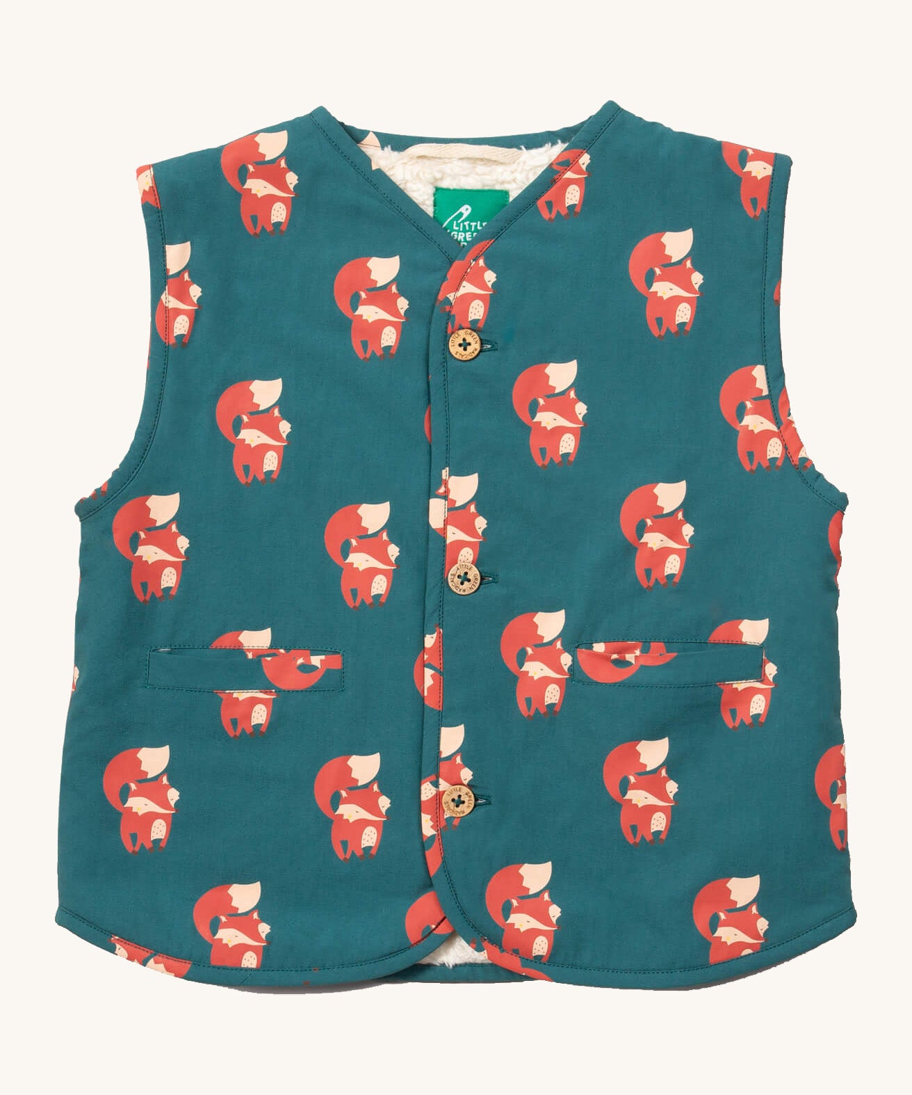 Little Green Radicals reversible gilet in red foxes and sherpa lined. A GOTS organic cotton gilet in teal with cute prints of foxes , 2 pouch pockets on the side and button fasteners. 