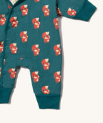 A close up of the Little Green Radicals sherpa line snow suit in red foxes. Showing the popper fastener detail and a close up of the red fox print on GOTS organic cotton fabric