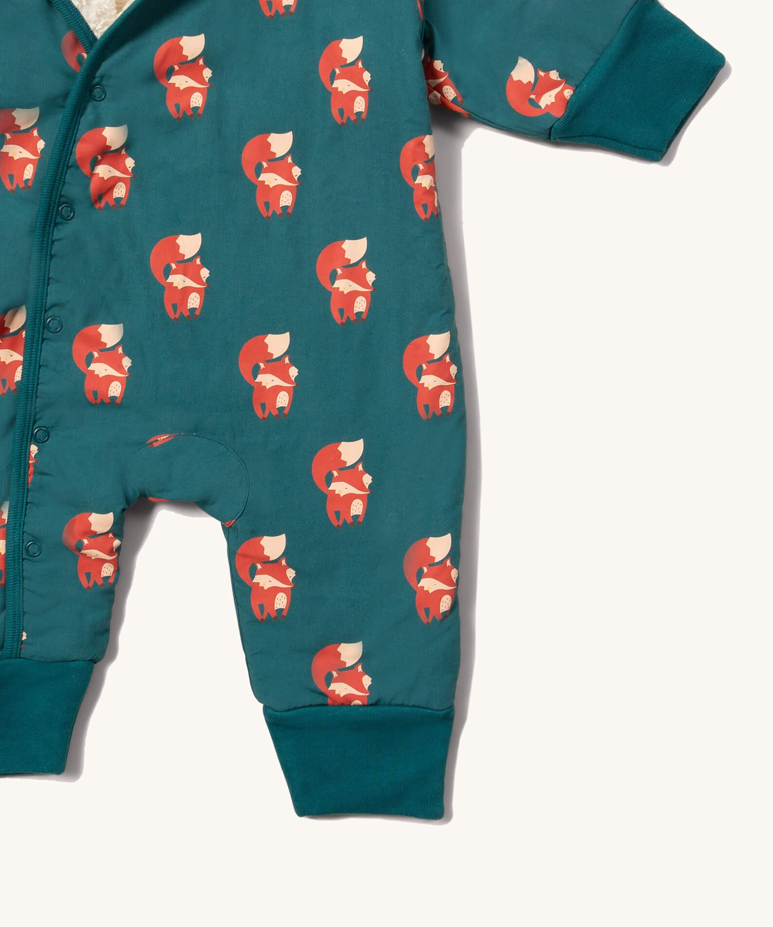 A close up of the Little Green Radicals sherpa line snow suit in red foxes. Showing the popper fastener detail and a close up of the red fox print on GOTS organic cotton fabric