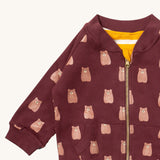 A close up of the Little Green Radicals reversible easy rider jacket in brown bears. Showing the zip detail which features a yellow toggle for easy opening and closing 