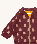 A close up of the Little Green Radicals reversible easy rider jacket in brown bears. Showing the zip detail which features a yellow toggle for easy opening and closing 