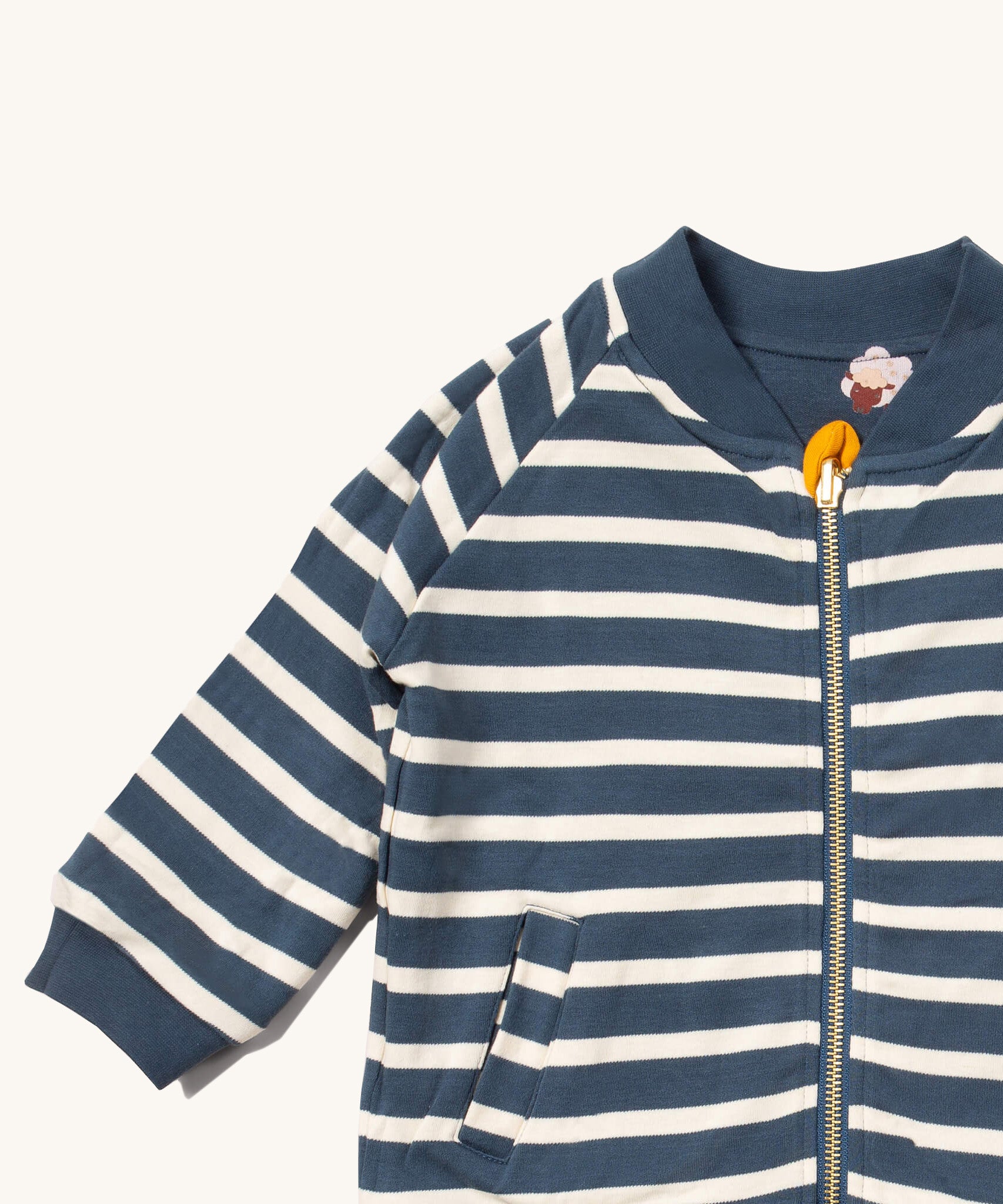 A close up of the Little Green Radicals reversible easy rider jacket in sleeping sheep. Showing the collar detail and zip detail which features a yellow toggle for easy opening and closing 