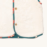 A close up of the Little Green Radicals reversible gilet in red foxes and sherpa lined. Showing the white sherpa fleece detail 